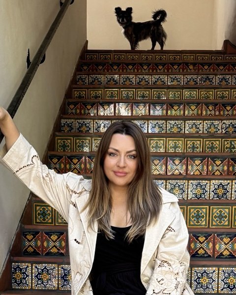 Delfina Alden, seated on a tiled staircase